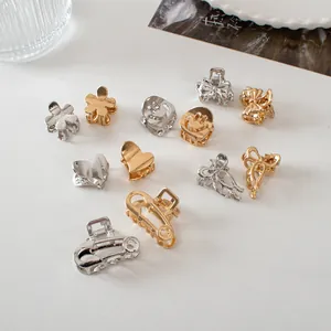 Close-up of assorted mini gold and silver metal hair claws in flower and heart shapes