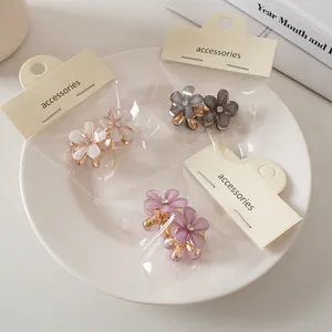 Dettaglio di mini mollette per capelli a fiori con strass e clip in metallo dorato in set