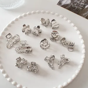 Detailed view of mini silver metal hair claws in heart, flower, and bow shapes