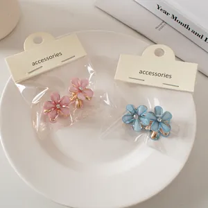 Mini mollette per capelli a fiore con strass in rosa e blu su cartoncino elegante