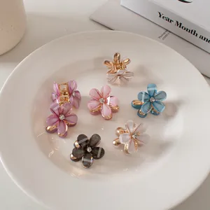 Dettaglio delle mini mollette per capelli a fiore con petali in resina e cristalli