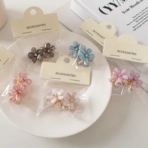 Dettaglio di mini mollette a fiore con petali in resina e centro di strass