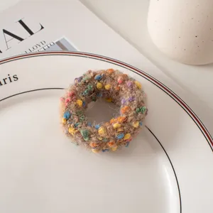 Détail d'un chouchou en maille kaki à pois sur une assiette en porcelaine avec éclairage doux