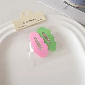 Detailansicht der rosa und grünen Wellenhaarklammern mit mattem Finish in Verpackung