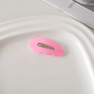 Rosafarbene matte Haarspange in Wolkenform mit silbernem Clip auf weißem Tablett
