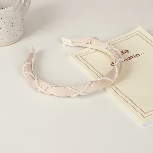 Creamy beige sponge headband with woven white pearls for an elegant hair accessory style