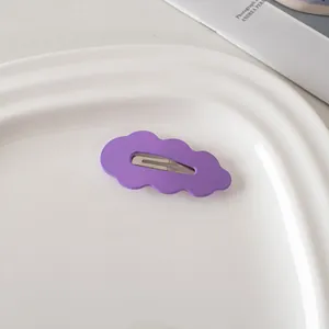 Detailansicht einer lila Haarspange in Wolkenform auf einem weißen Dekoporzellanteller