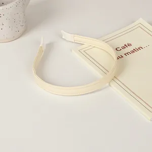 Beige faux leather headband with fine stitching and soft fabric ends for comfort
