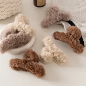 Dettaglio macro di grandi mollettoni in peluche nei toni della terra per look invernali