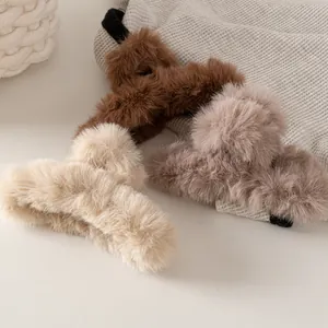 Dettaglio ravvicinato di pinze per capelli in peluche marrone, crema e rosa per l'inverno
