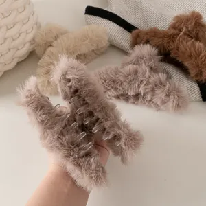 Dettaglio di pinze per capelli in pelliccia sintetica beige e marrone per acconciature