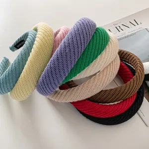 Detail of thick ribbed knit headbands with handmade woven labels in various colors