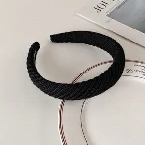 Detailed macro view of black ribbed knit wide headband with soft textured fabric