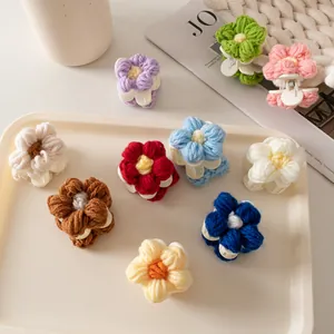 Détail de mini pinces à cheveux en forme de fleurs tricotées aux textures crochetées