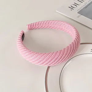 Detail of pink knitted headband with handmade label and elegant woven texture