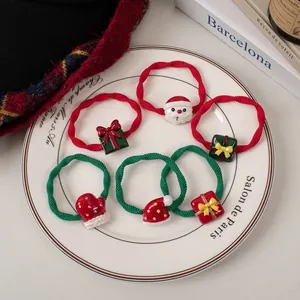 Set of 6 Christmas hair scrunchies with Santa and gift resin charms on a white plate