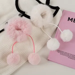 Details von pinkfarbenen und weißen Plüsch-Haargummis mit weichen Kunstfell-Pompons