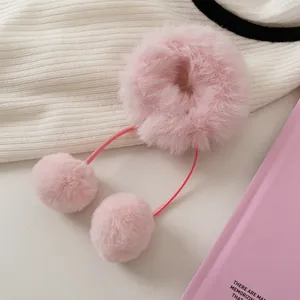 Detailansicht des rosa Plüsch-Haargummis mit weichen Pompons und hängenden Bändern
