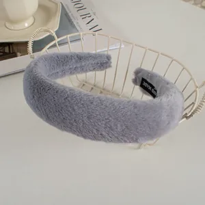Detailed view of gray faux rabbit fur headband with handmade label in a lifestyle setting