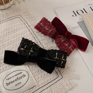 Detail of velvet and tweed bow hair clips in black and burgundy with golden threads