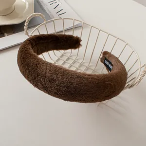 Detail of a thick dark brown faux rabbit fur headband with a handmade inner woven label