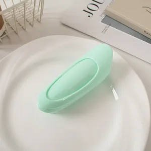 Macro shot of mint green hair root volume clip on white plate with journals