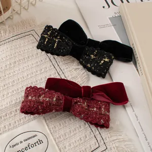 Close-up of velvet and tweed double bow hair clips in elegant black and burgundy red