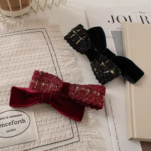 Detail of tweed and velvet double bow hair clips in black and wine red colors