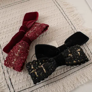 Close-up of vintage velvet and tweed bow hair clips in burgundy and black colors