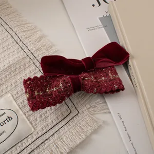 Close-up of velvet and tweed wine red bow hair clips on elegant background