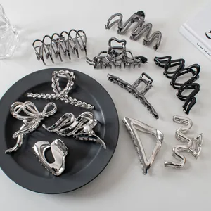 Detail shot of assorted silver and dark metal hair claws in geometric and bow shapes