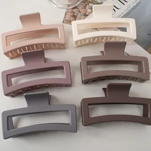 Vista piatta di sei grandi mollette quadrate opache per capelli in delicati colori Morandi