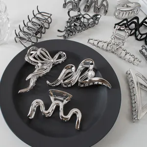 Macro detail of various metallic hair claws with pearl accents in silver and gunmetal