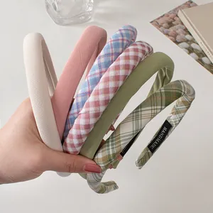 Detail of five handmade fabric headbands with sponge padding in solid colors and plaid patterns