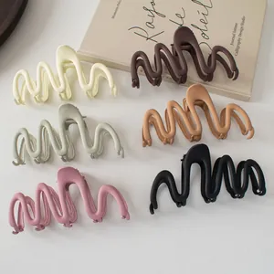 Detailed grid of large matte wave hair claws in beige, green, pink, and brown tones