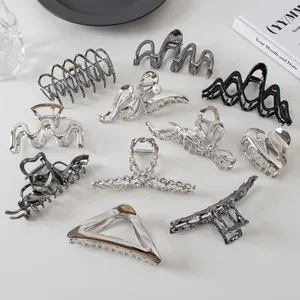 Various silver and black metal claw clips with geometric patterns and pearl details