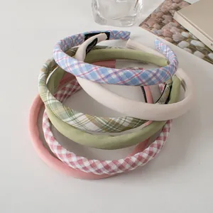 Detail of fabric sponge headbands in solid and plaid patterns with handmade label