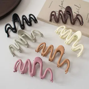 Close-up of matte wave large hair claw clips in assorted earth tones and pastel colors