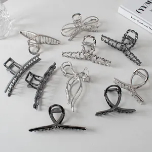 Detailed view of large silver and gunmetal hair claws in various metallic designs
