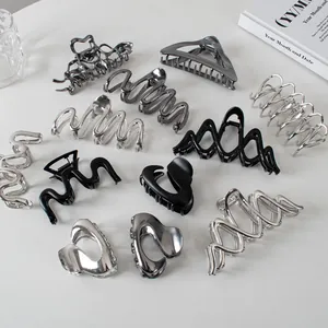 Variety of silver and black metal hair claws in wave and geometric cutout designs