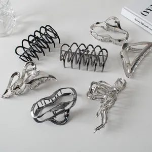 Detail of silver alloy hair claws featuring minimalist wave and pearl designs