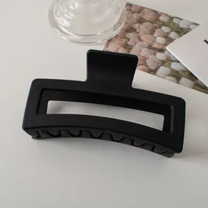 Dettaglio molletta per capelli rettangolare nero opaco con design geometrico vuoto