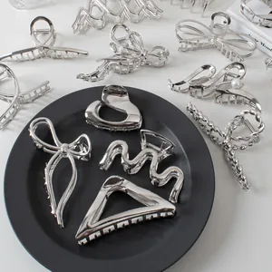 Collection of large silver metal hair claws in geometric and bow shapes for elegant styling