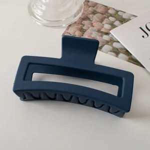 Vista macro di una pinza per capelli rettangolare blu navy opaco da 13cm per capelli folti