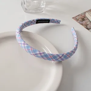 Detail view of a handmade fabric checkered headband with blue and pink patterns