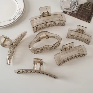 Detailed set of six translucent grey hair claws in various geometric shapes on a white table