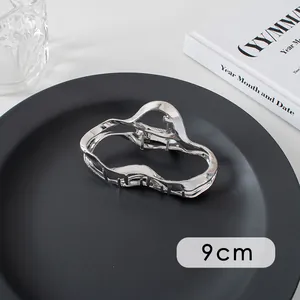 Detail shot of a 9cm silver metal hair claw clip with a wave-shaped cutout design