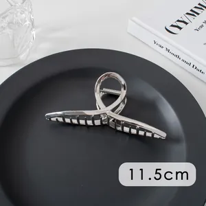 Detail showing an 11.5cm large silver metal hair claw clip with cross hollow design