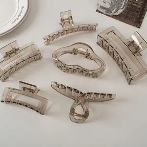 Set of six large smoky grey hair claws in various geometric shapes on a clean white surface