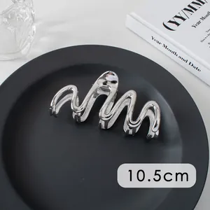 Detailed view of a 10.5cm silver metallic shark hair claw clip with wavy lines design